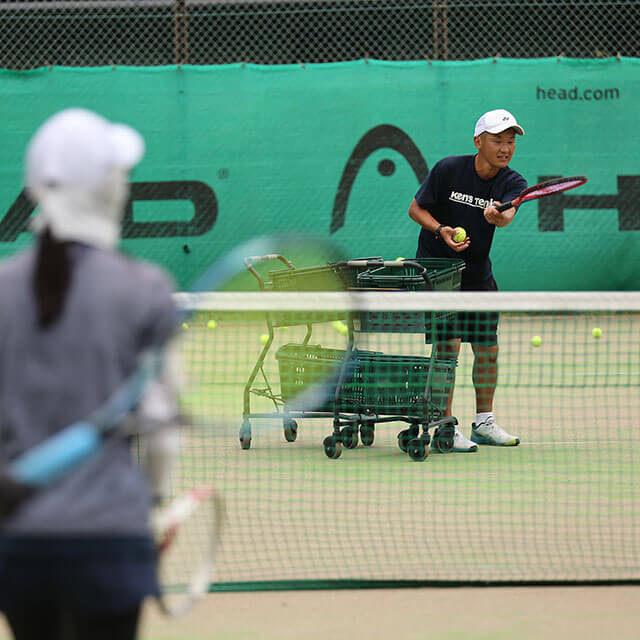 テニスを指導するコーチ